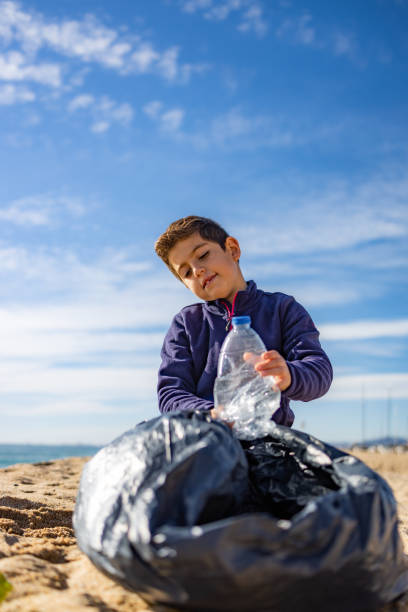 istock Little kid picking plastic on the beach. Recycling concept 1362685173
