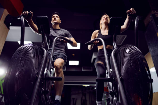 istock Fitness couple practicing on exercise bike in a gym. 1362685528