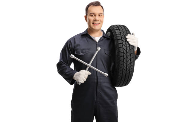 istock Auto mechanic carrying a tire and holding a wrench tool 1362686359
