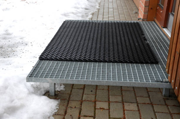 staircases made of steel gratings with rubber anti-slip mats. the mat at the cottage is on a raised staircase, snow removal from ski boots is much easier. winter surroundings of a mountain hut escaleras fabricadas en rejillas de acero con alfombrillas antideslizantes de goma. la colchoneta en la cabaña está en una escalera elevada, la eliminación de nieve de las botas de esquí es mucho más fácil. entorno invernal de un refugio de montaña