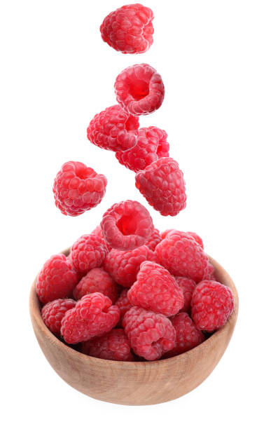 istock Fresh ripe tasty raspberries falling into bowl on white background 1362687382