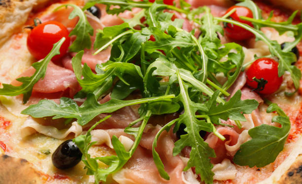 istock Tasty pizza with meat and arugula as background, closeup view 1362687587