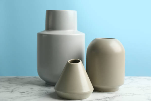 istock Stylish empty ceramic vases on white marble table against light blue background 1362687953
