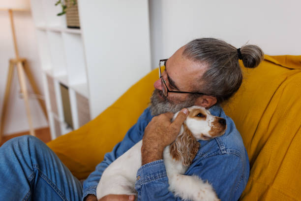 istock Mature man and his pet relaxing at home 1362689508