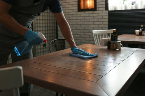 istock Waiter in gloves disinfecting table at cafe, closeup 1362691950