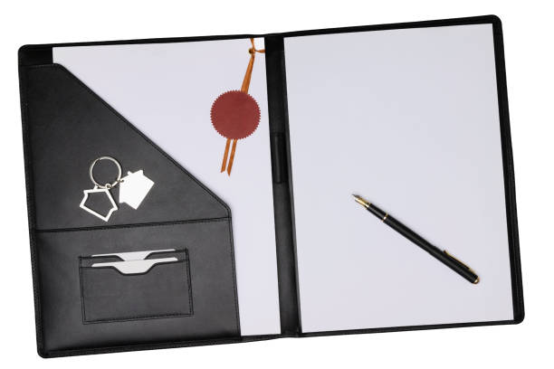 Black leather notepad cover opened with white blank paper sheet and pen isolated on white with document tied and sealed by notary public sticker