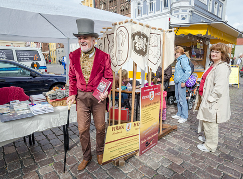 Craft market trader in traditional German costume, Stralsund, Germany