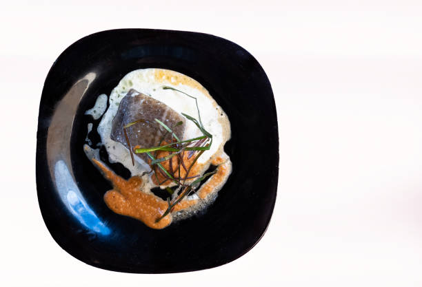 istock Cod fillets with chives in sauce on white background. Top View 1362693622