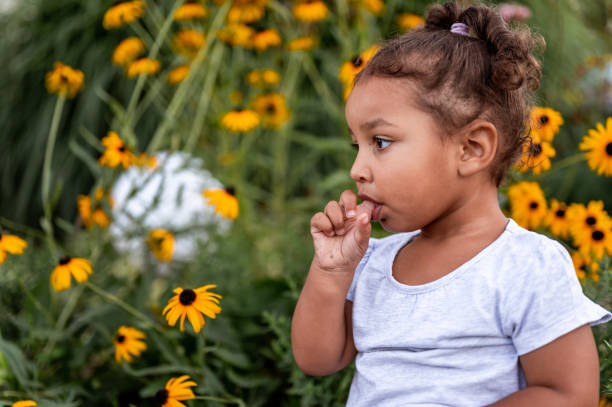 niña con un dedo en la boca al aire libre - finger in mouth fotografías e imágenes de stock