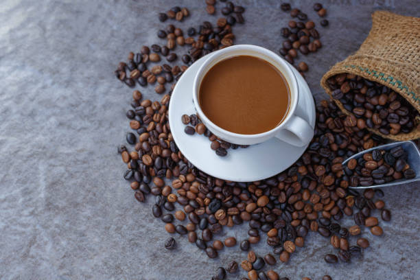 istock Coffee cup and roasted coffee beans in brown bag, top view. 1362697288