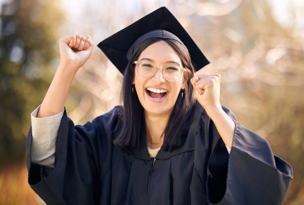 졸업일에 응원하는 젊은 여성의 사진 - graduation women fist celebration 뉴스 사진 이미지