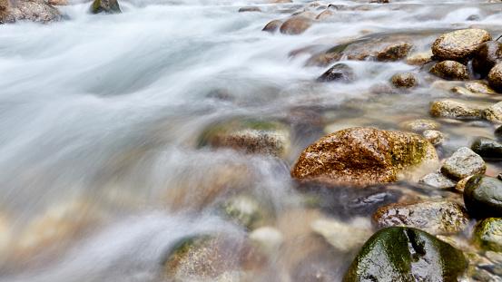 a mountain river flowing over rocks. blurred motion background photo