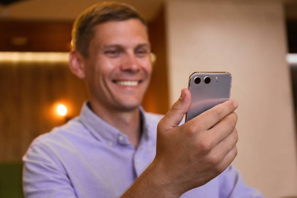 istock Businessman with smartphone in cafe, focus on hand 1362699715