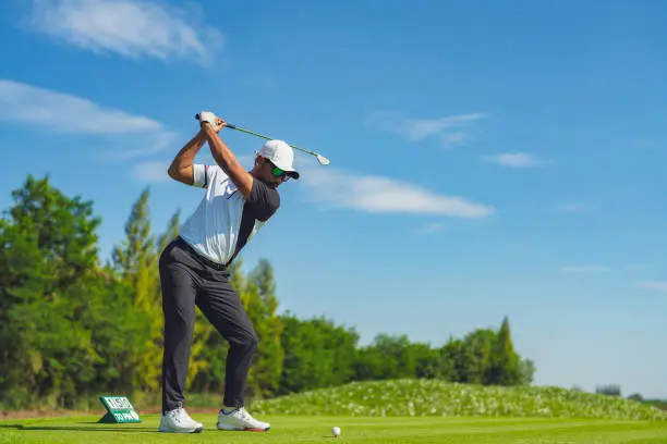 Photo of Asian man golfing on the course in summer