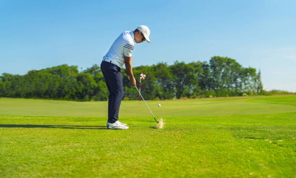 asiatischer mann beim golfen auf dem platz im sommer - golf golf club golf swing tee stock-fotos und bilder
