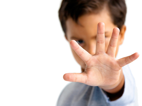 Image of young boy with hand outstretched, warding off any unwelcome situations.