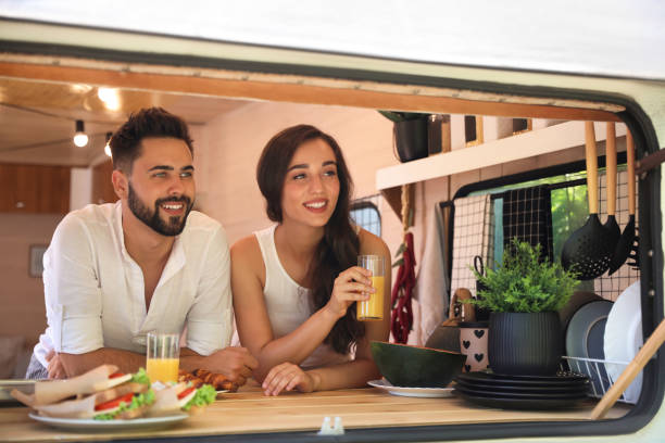 istock Happy young couple having breakfast in trailer. Camping vacation 1362703341