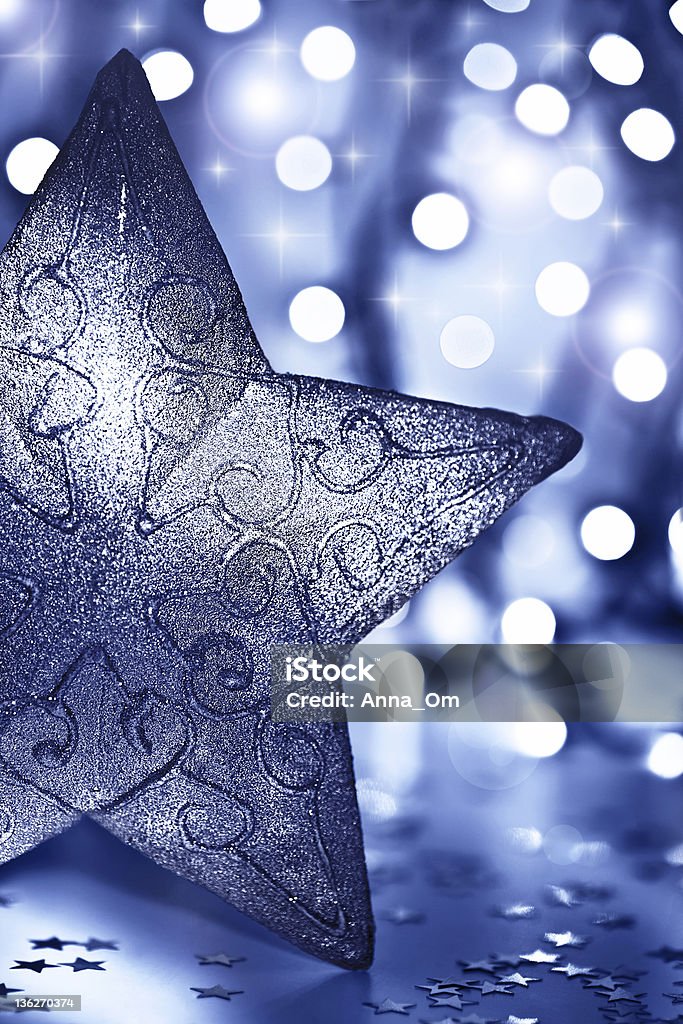 Star decoration, Christmas tree ornament Star decoration, Christmas tree ornament, beautiful blue silver bauble over abstract blur bokeh lights background, decorating home at winter holidays, new year eve Blue Stock Photo