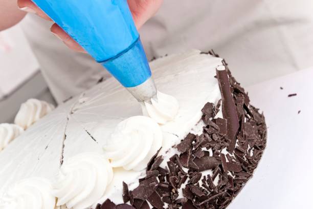istock Decorating a cake with cream swirls 1362705881