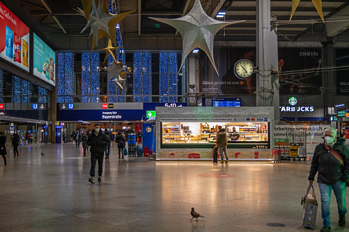 Food stall and Christmas decorations in the hall of the main railroad station in the German city Munich, which is the capital city in Bavaria