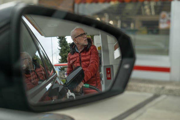 starszy mężczyzna tankujący swój samochód na stacji benzynowej - station gasoline old fuel pump zdjęcia i obrazy z banku zdjęć