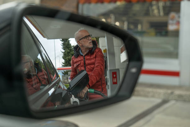 пожилой мужчина заправляет свой автомобиль на заправке - station gasoline old fuel pump стоковые фото и изображения