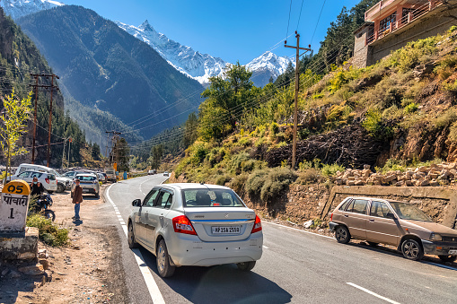 Himachal Pradesh, India, October 26, 2021: Tourist vehicles on scenic national highway road from Kalpa to Narkanda at Himachal Pradesh with majestic Himalayan range