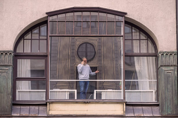 Businessman seen through a fancy window having a discussion on his mobile phone in the center of the German city Munich, which is the capital city in Bavaria