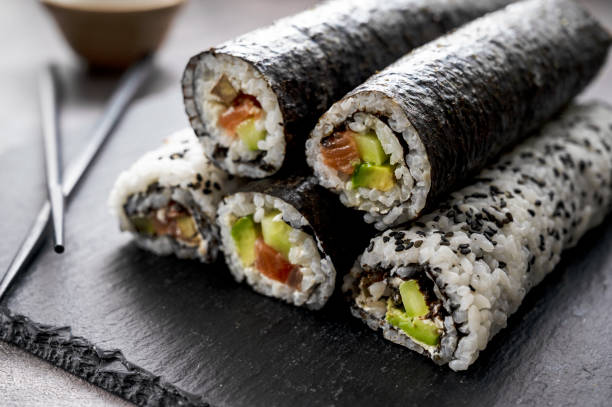 Sushi rolls. Homemade rolls with salmon, avocado and cucumber. Sushi rolls. Homemade rolls with salmon, avocado and cucumber nori stock pictures, royalty-free photos & images