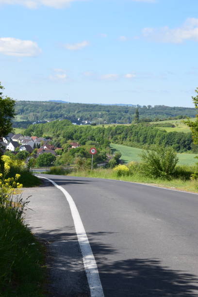 istock modern road into an Eifel valley with a village 1362707428