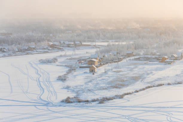 vista dalla collina alla città di yakutsk nella nebbia in una fredda sera d'inverno - mountain snow sunset house foto e immagini stock