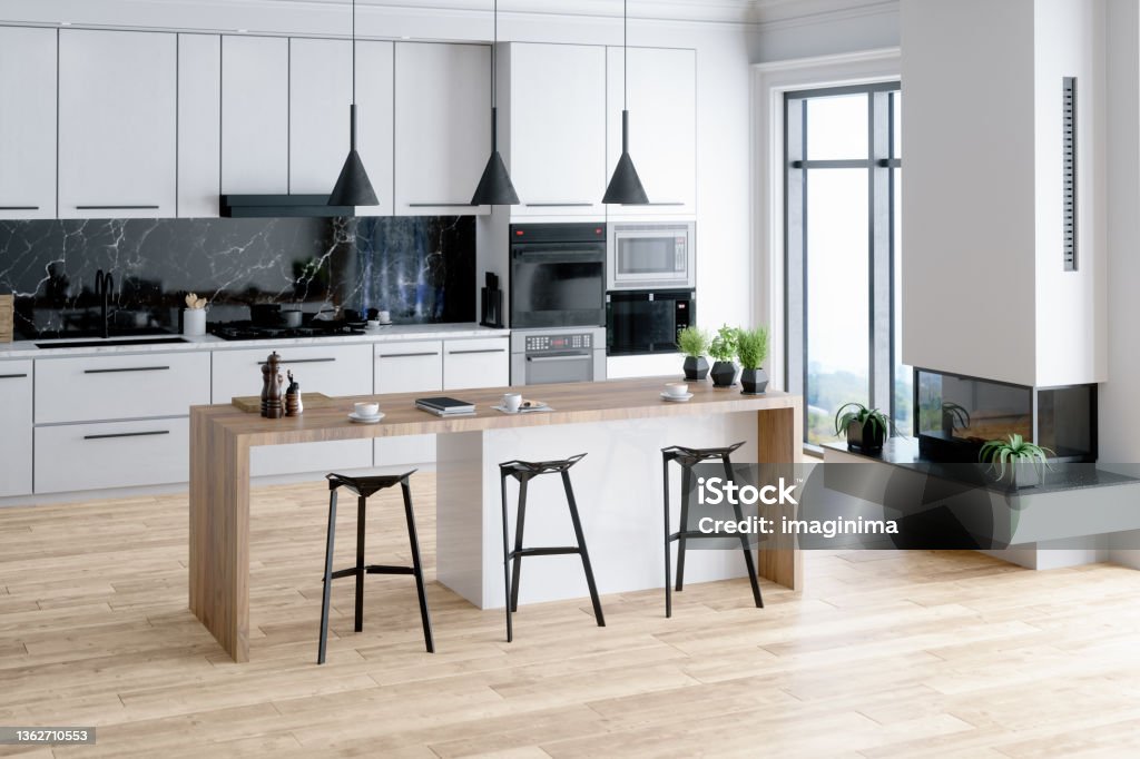 Beautiful Kitchen In Luxury Home With Island Modern kitchen interior with island, sink, cabinets, kitchen appliances and hardwood floor in a new luxury home. Kitchen Stock Photo