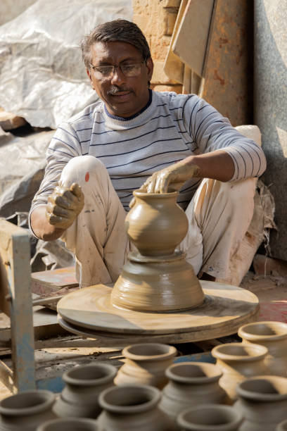 istock Man making clay pot on spinning wheel 1362713548