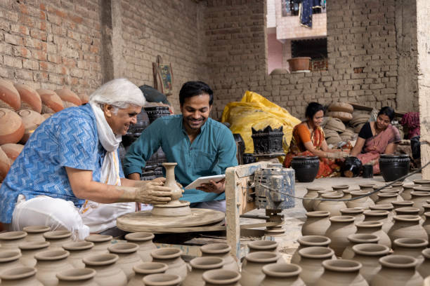 istock Indian family manufacturing and painting pots while using digital tablet at workshop 1362713715