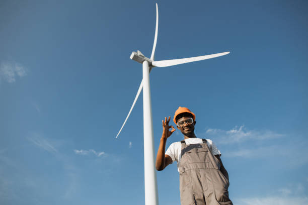 istock Engineer in uniform gesturing sign ok at windmill farm 1362713787