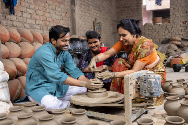 istock Indian family making clay pot on spinning wheel 1362713855