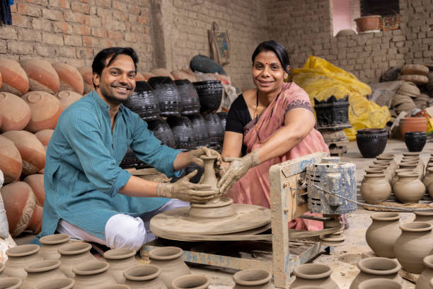 istock Couple making clay pot on spinning wheel 1362713903
