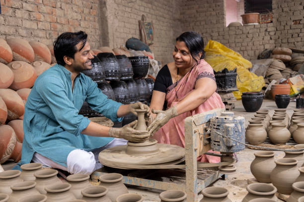 istock Couple making clay pot on spinning wheel 1362713963