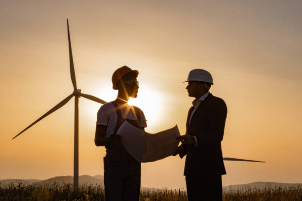 istock Multiracial colleagues examining wind turbines blueprints 1362713986