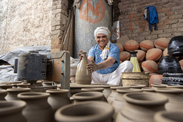 istock Man making clay pot on spinning wheel 1362714173