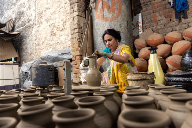 istock Woman making clay pot on spinning wheel 1362714175