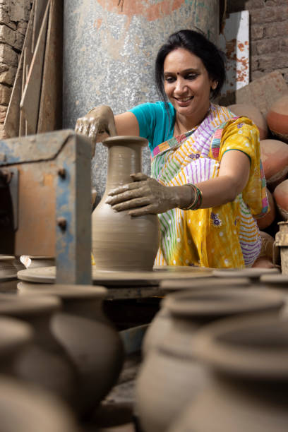 istock Woman making clay pot on spinning wheel 1362714194