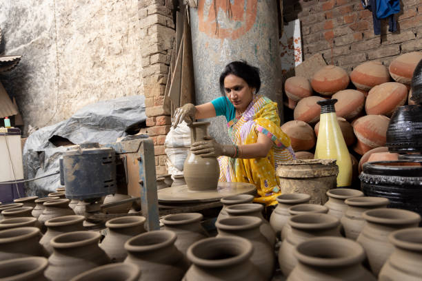 istock Woman making clay pot on spinning wheel 1362714198