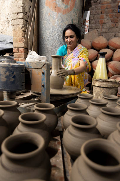 istock Woman making clay pot on spinning wheel 1362714199