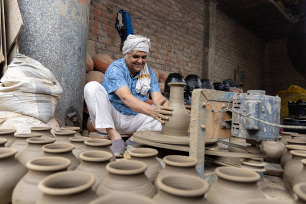 istock Man making clay pot on spinning wheel 1362715253