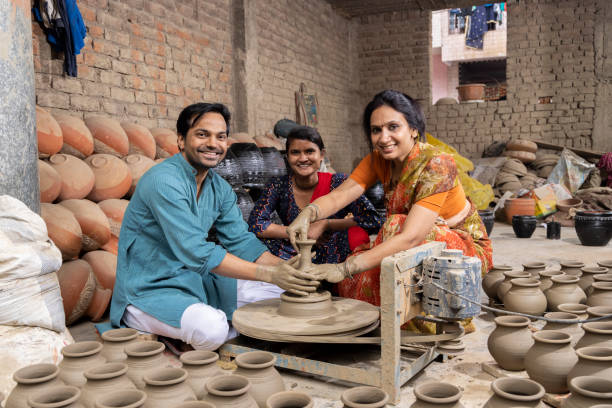 istock Indian family making clay pot on spinning wheel 1362718604