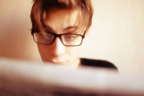 Young man reading a newspaper with emotions on his face isolated