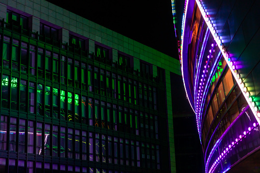 Exterior wall with lights. Night modern building rainbow colorful window lighting