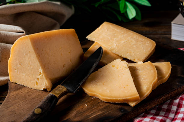 stück von einem letzten italienischen provolone-käse und frisch geschnittenen fetas auf dem brett. normalansicht - tellerlift stock-fotos und bilder