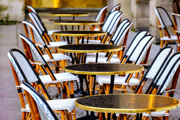 wet tables and chairs in the row - french restaurant stock photo